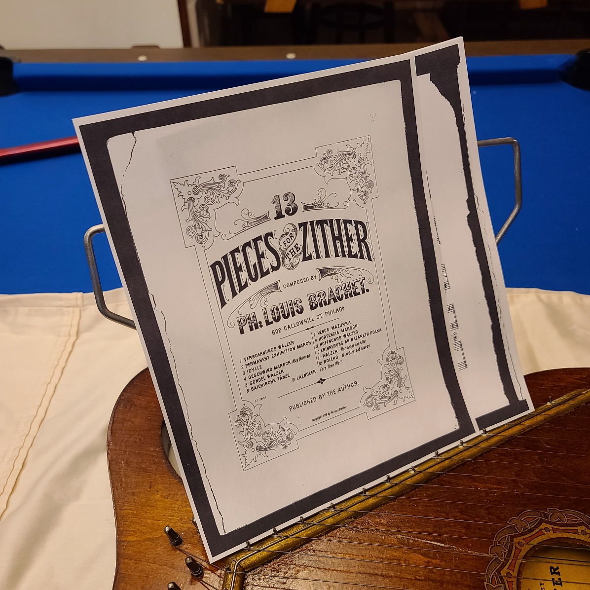 Music stand holding sheet music for playing in the original zither position.